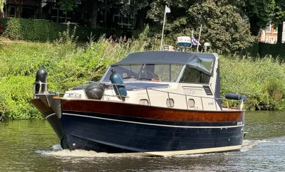 motorjacht op kanaal langs groene oever