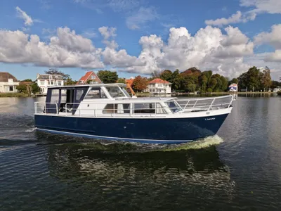 motorjacht op rustige waterweg bij huizen