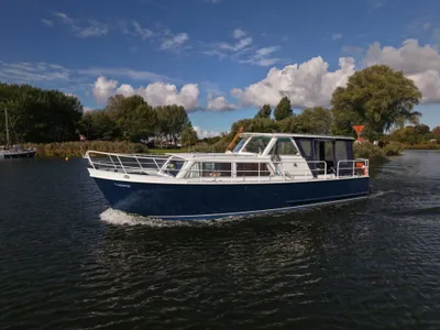 motorjacht varend op water bij beboste oever