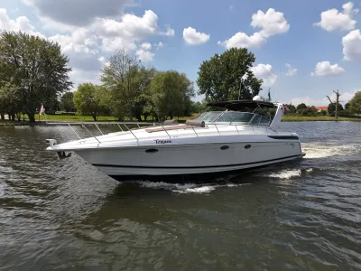 motorjacht varend op rivier bij bomen