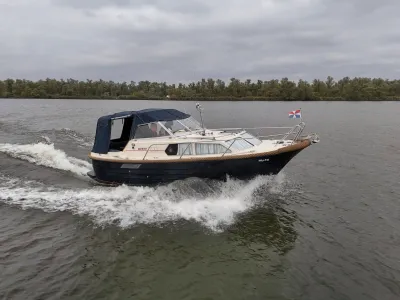 cabinsloep varend met boegslag op rivier