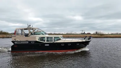 motorjacht op water langs rietkade