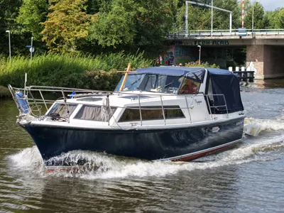 Motorjacht varend op kanaal bij brug