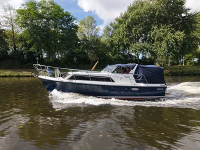 motorjacht varend op kanaal met bomen