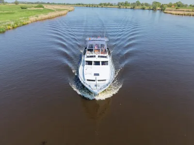 wit motorjacht varend op rivier