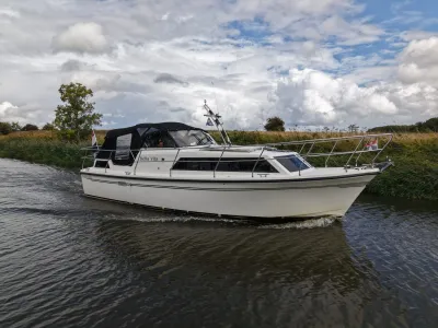 motorjacht op kanaal bij grasoevers
