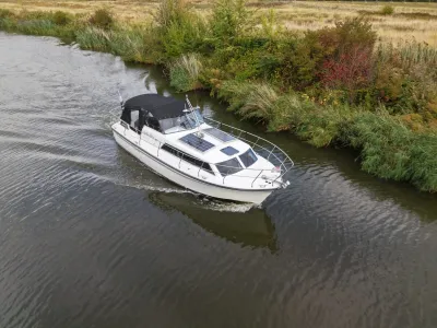 motorjacht op kanaal bij rietwal
