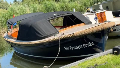 houten sloep afgemeerd met zwarte kap