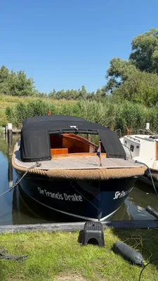 Houten sloep afgemeerd bij een aanlegsteiger