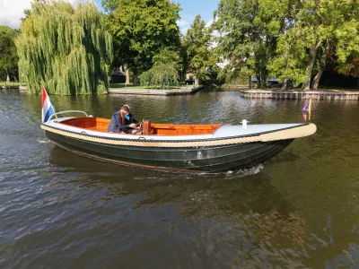 vlet op kanaal met bomen op de oever