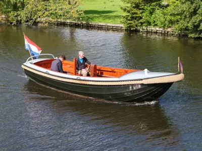 houten sloep met twee personen op het water