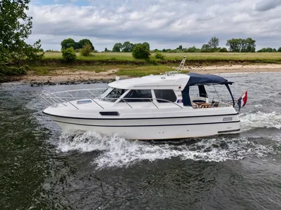 witte motorboot varend langs kust