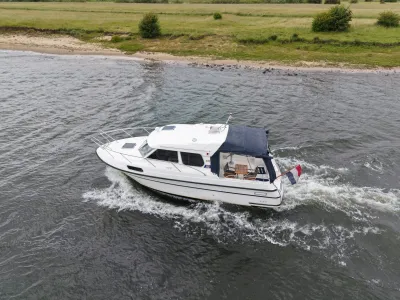 witte motorboot op rivier bij oever