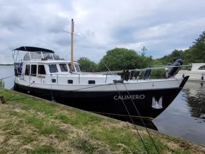 motorjacht aangemeerd bij gras- en waterkant