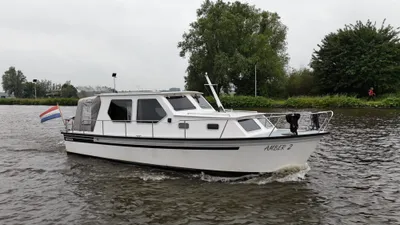 Wit motorjacht varend op een kanaal