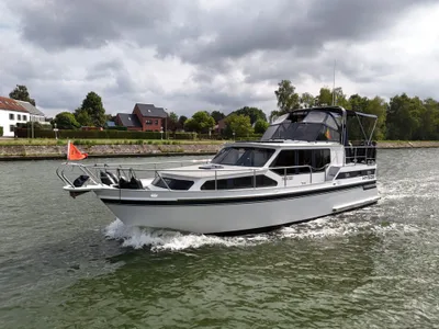 motorjacht varend in kanaal bij woonwijk