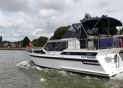 motorjacht op kanaal met oever en wolken
