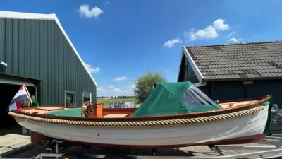 sloep op trailer bij loods
