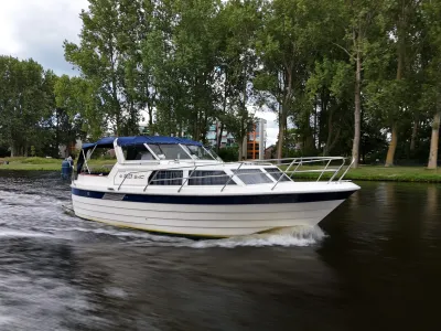 motorboot varend op kanaal met bomen op oever