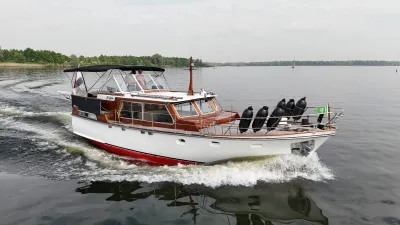 motorjacht met houten opbouw op het water