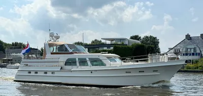 wit motorjacht op rivier voor woonhuizen