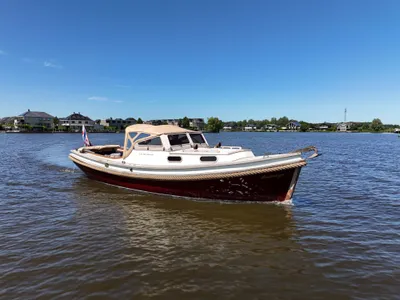 kleine motorboot op water met huizen op achtergrond