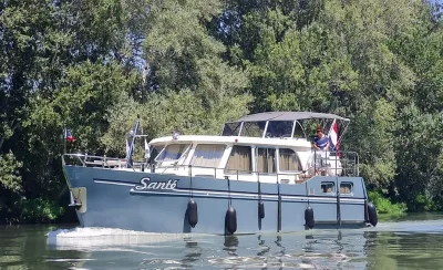 motorjacht op rustig water met bomen op achtergrond