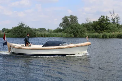 witte sloep op water met bestuurder