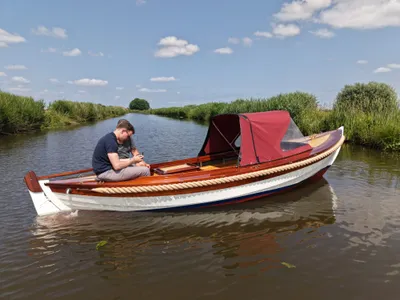 houten sloep met kuiptent op rivier