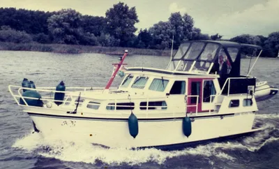 wit motorjacht op binnenwater met bemanning