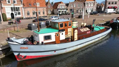 klassieke sleepboot afgemeerd bij kade