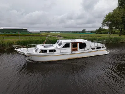 wit motorjacht op kanaal bij landbouwgebied