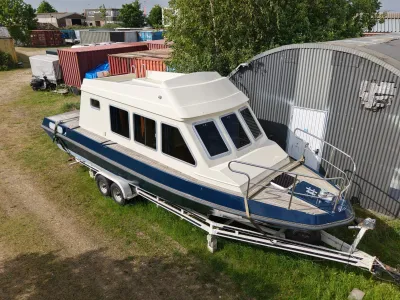 motorjacht op trailer bij loods