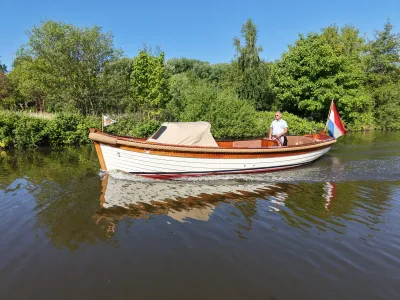 houten sloep op kanaal met bestuurder