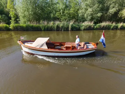 houten sloep op kanaal met persoon