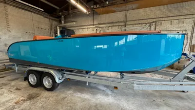 turquoise tender op trailer in loods