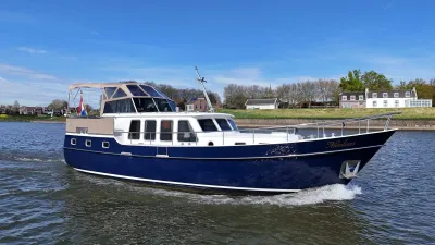 blauw motorjacht op rivier bij oever