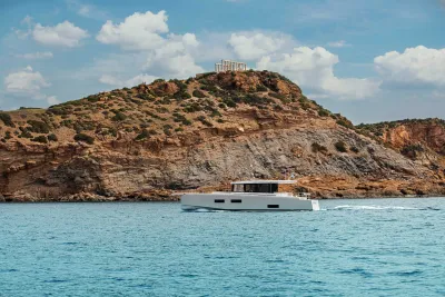 wit motorjacht bij rotskust