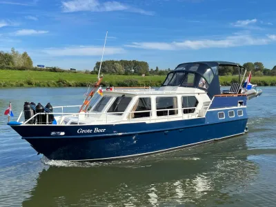 blauwe motorjacht op rivier bij groene oever