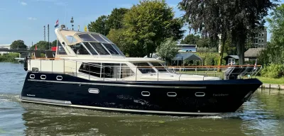 motorjacht op vaarwater langs groen oever