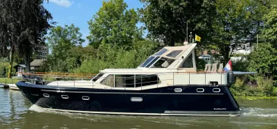 Motorjacht varend langs groene oever