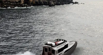 motorboot op zee nabij rotsachtige kust