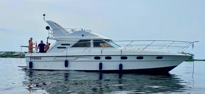 wit motorjacht met personen op rustig water