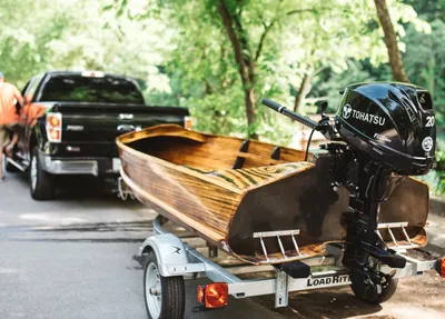 houten boot op trailer met buitenboordmotor
