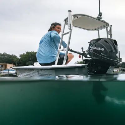 man op kleine boot met buitenboordmotor
