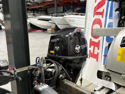 buitenboordmotor in showroom met boten op de achtergrond