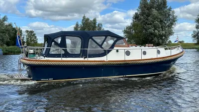 blauwe motorvlet met kuiptent varend op water