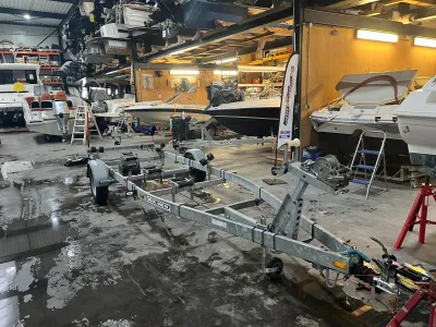 boottrailer in werkplaats met boten op achtergrond
