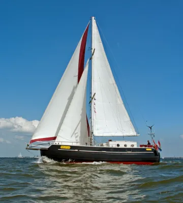 zeilboot op open water bij blauwe hemel