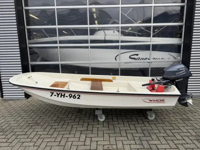 open motorboot met buitenboordmotor bij garage